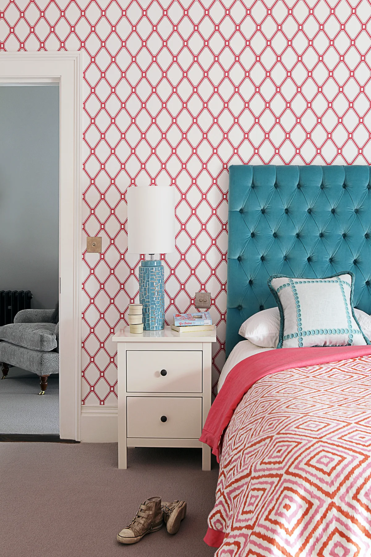Turquoise velvet headboard against pink patterned wallpaper in the Regency house, Dublin